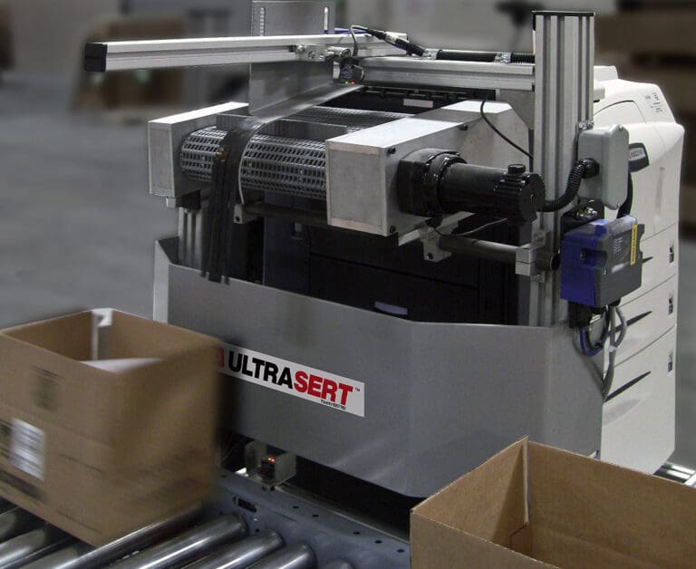 document insertion being automated on conveyor with shipping boxes